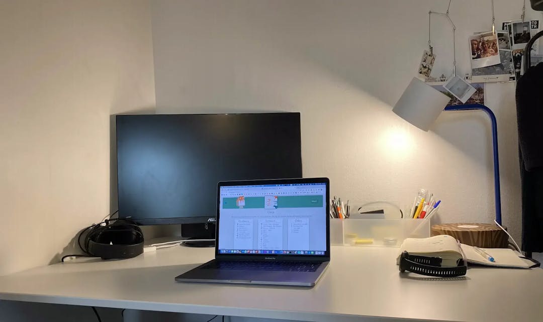 Workplace - laptop, external monitor, lamp, pens, notebook, etc.